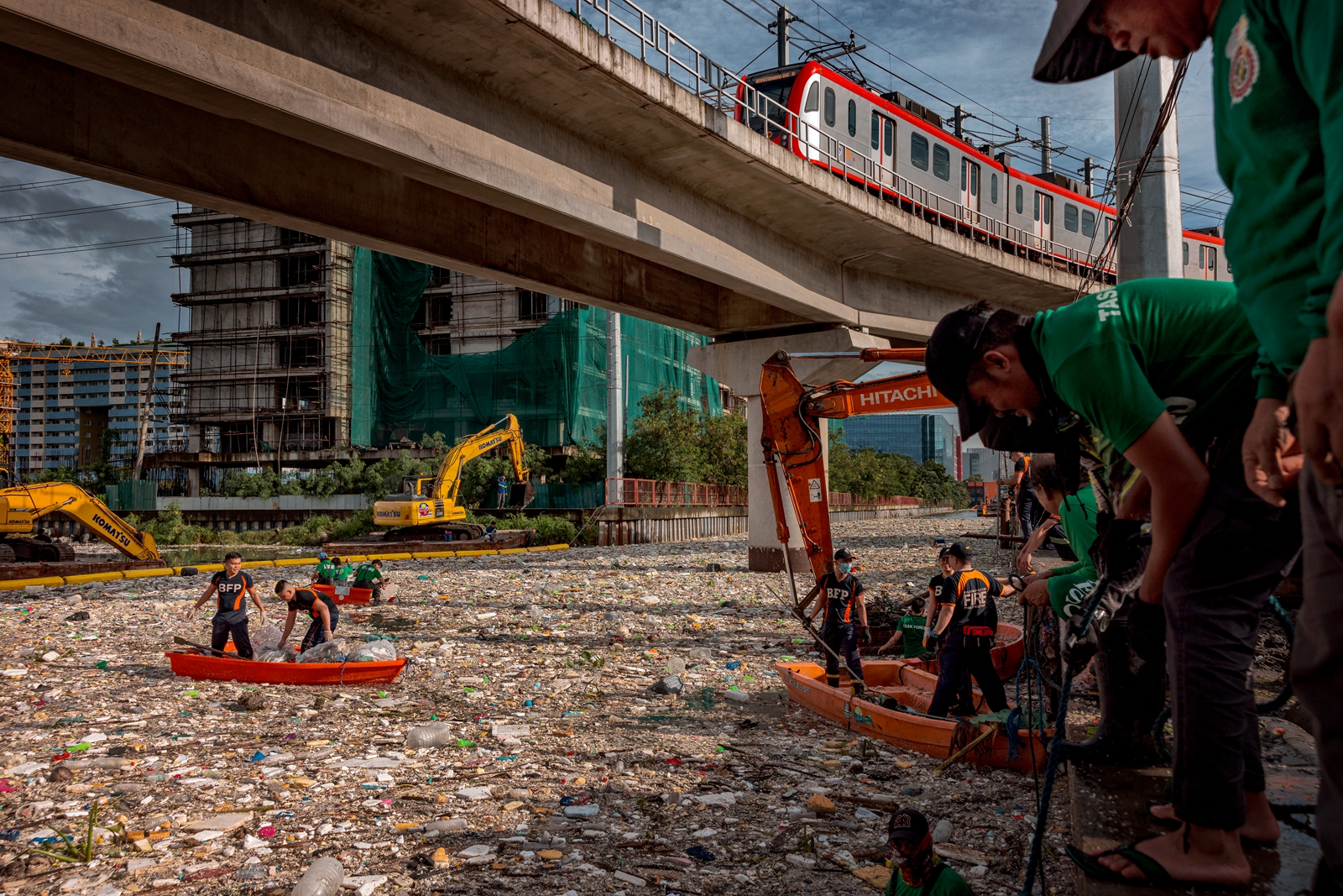 2026年8月12日，在馬尼拉郊區的帕拉尼亞克市（Paranaque），連日豪雨把大量垃圾衝入當地河道，當局調派多名工人清理河中堆積的垃圾。（Ezra Acayan/Getty Images）