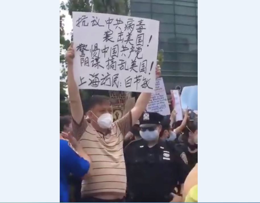 上海訪民白節敏在紐約舉牌抗議中共，並提醒要警惕中國共產黨陰謀搞亂美國。（白節敏提供）