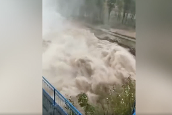 山西省暴雨已導致大橋橋台衝垮、河流決堤。圖：現場片段顯示，晉中市祁縣子洪水庫洩洪，怒濤翻滾。（影片截圖）