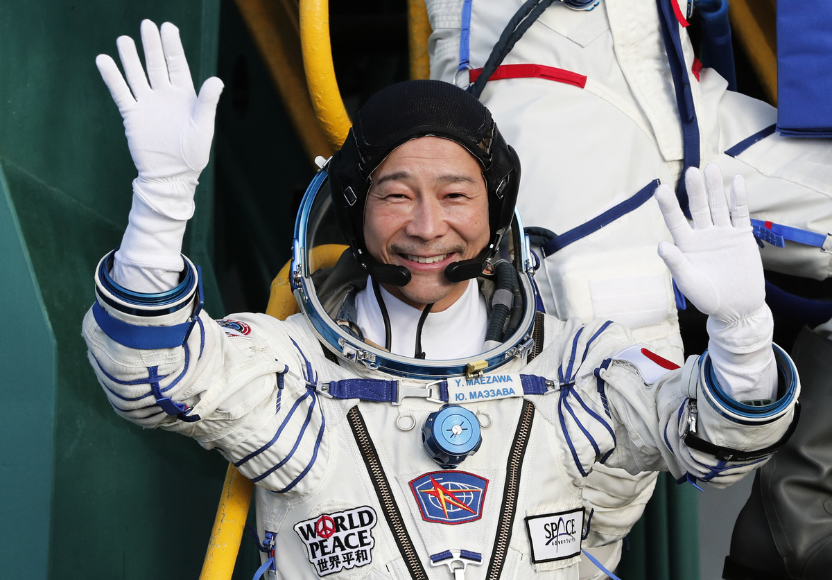 2021年12月8日，日本億萬富翁前澤友作在登上飛船時向人們揮手致意。（Shamil Zhumatov/POOL/AFP via Getty Images）