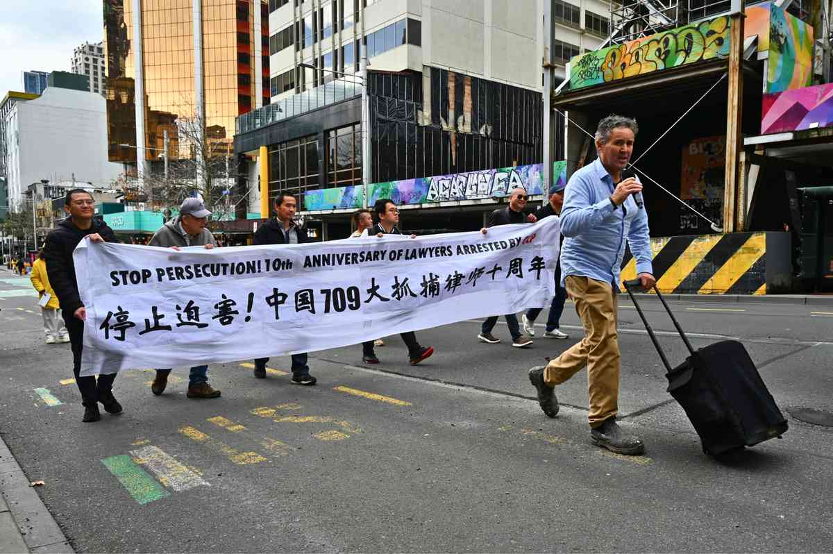 2025年7月19日,紐西蘭部份法輪功學員齊聚奧克蘭市中心伊利沙伯廣場,舉行反迫害26周年集會,並在皇后街進行了聲勢浩大的「解體中共、結束迫害」的遊行活動。圖為流亡民運人士在集會遊行活動中呼籲停止迫害。(趙凱/大紀元)