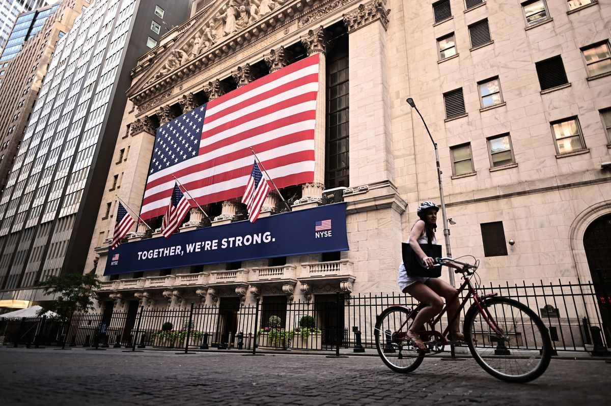 2020年7月13日，在紐約市華爾街，一名女子騎車從紐約證券交易所（NYSE）經過。（JOHANNES EISELE/AFP via Getty Images）