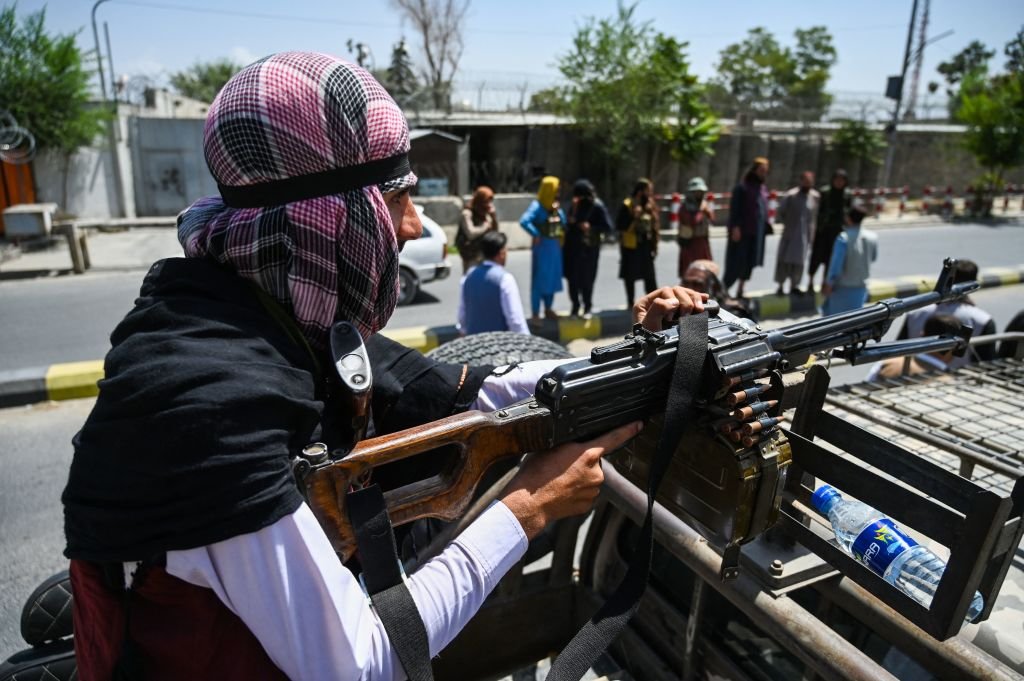 一名塔利班武裝份子在車輛頂部配備機槍，並在喀布爾的一條街道上巡邏。（WAKIL KOHSAR/AFP via Getty Images）