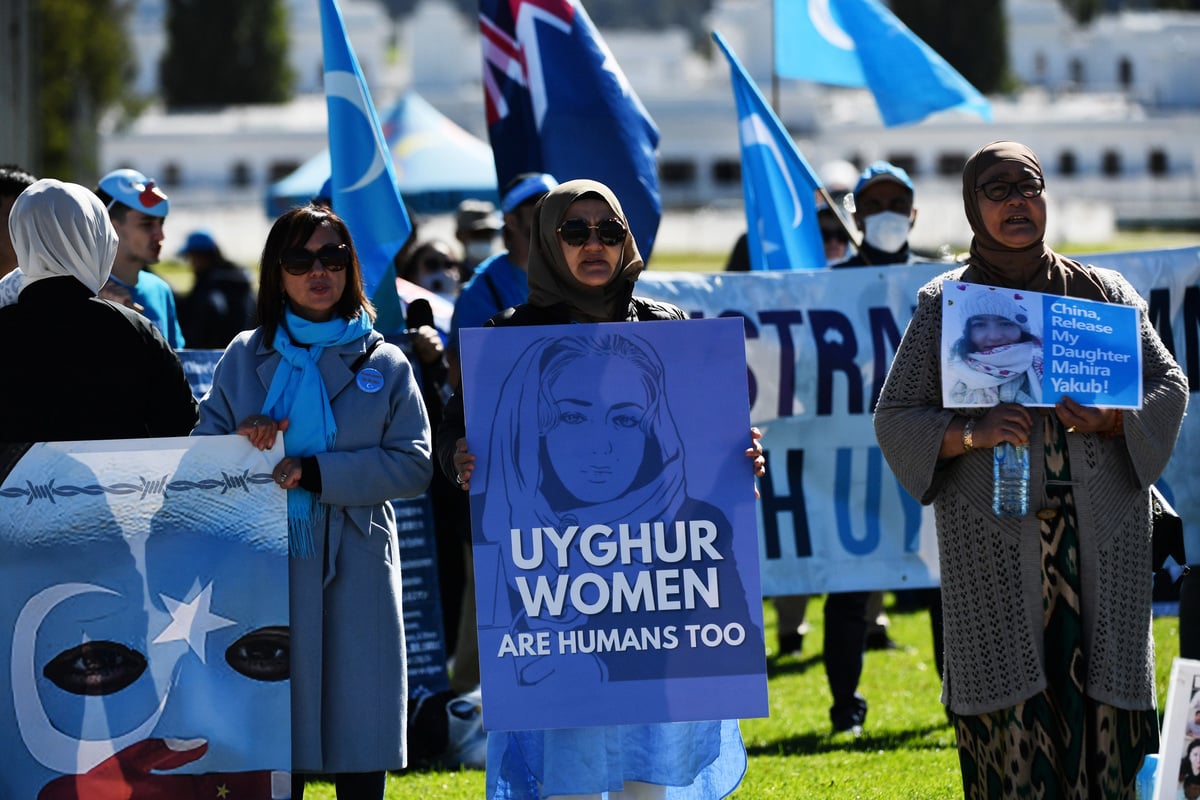 圖為2021年3月15日，新疆人在澳洲坎培拉國會大廈外舉行抗議活動，一名抗議者舉著寫有「維吾爾族女人也是人」的牌子。（Sam Mooy/Getty Images）