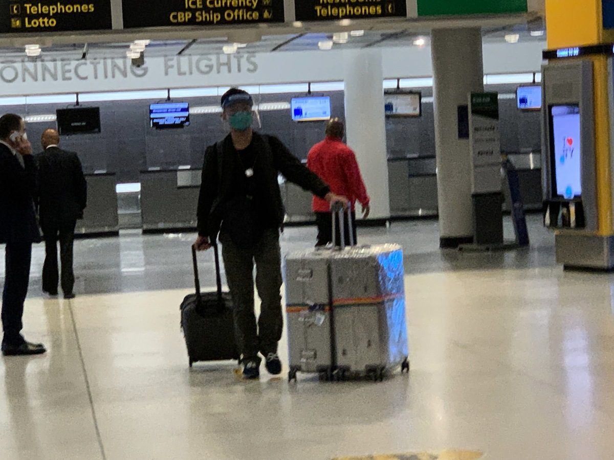 2021年8月18日晚，一名中國留學生帶著三箱行李，戴著口罩、護目鏡抵達紐約JFK國際機場。他說同一架飛機上，有很多中國留學生。（林丹／大紀元）