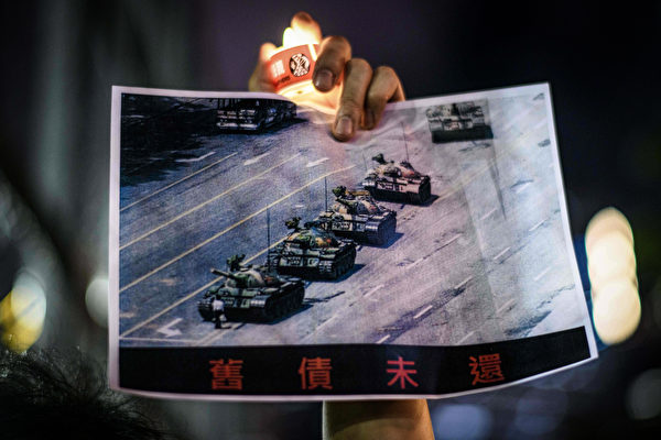 2020年6月4日,在香港維多利亞公園舉行的1989年天安門廣場事件紀念活動中,有人手持著名的「坦克人」(Tank Man)圖片。(Anthony Wallace/AFP via Getty Images)