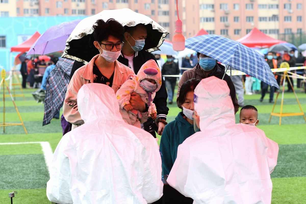 2020年10月14日山東省青島市民在雨中排隊接受核酸檢測。（STR/AFP via Getty Images）