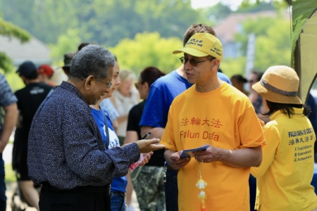 2025年6月7日下午,加拿大首都的斯蒂茨維爾(Stittsville)多元文化節在Village Square公園舉行,這個年度活動由市議員高沃(Glen Gower)主辦,今年參加的人數超過千人。圖為法輪功學員向社區人士介紹法輪功。(任僑生/大紀元)