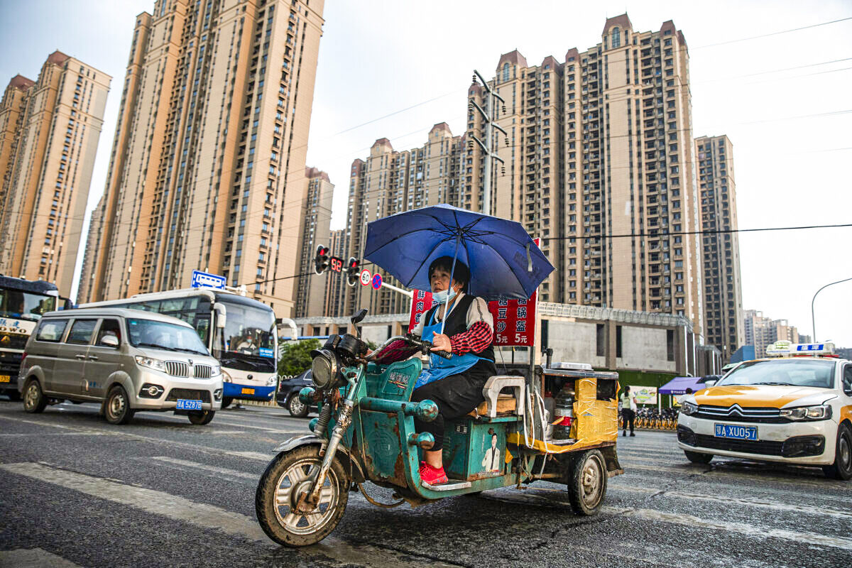 2021年9月24日，一名小販在雨中騎車經過武漢市恒大長青社區。（Getty Images）