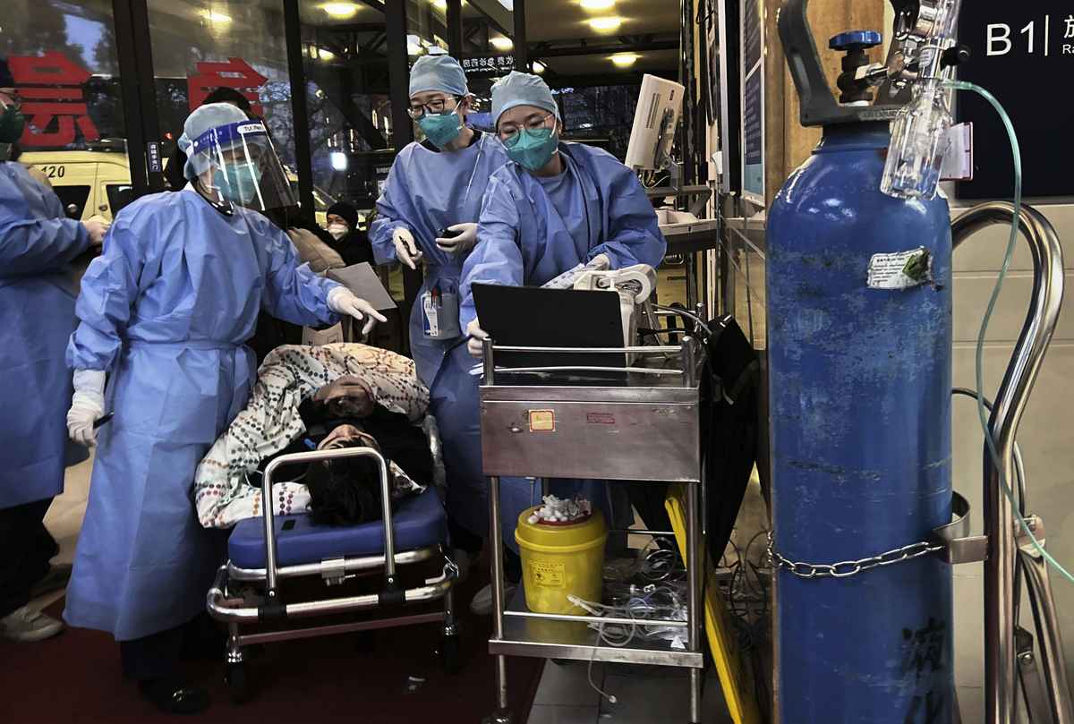圖為2023年1月14日，上海一家繁忙的醫院門口，醫務人員在收治病人。（Kevin Frayer/Getty Images）