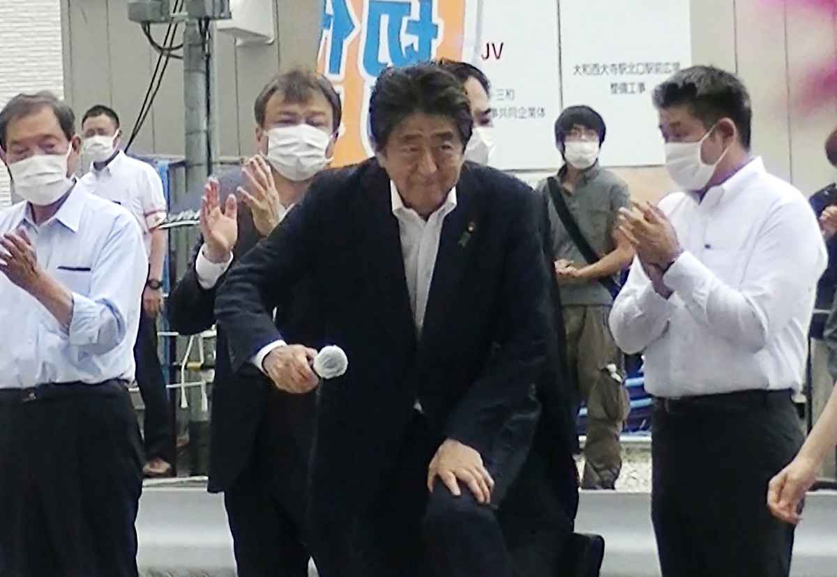 2022年7月8日，日本前首相安倍晉三（Shinzo Abe）在一次競選活動中被槍殺。圖為他在當天的活動中發表演講。疑犯槍手是那位站在其身後穿灰衣者。（Toshiharu Otani/JIJI PRESS/AFP）