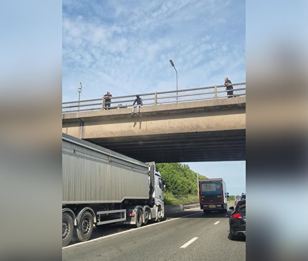 男子想在高速公路橋上自殺，一位長途卡車司機把車停在這名男子下面，以防不測。（由利茲弱勢公民支持組織提供）