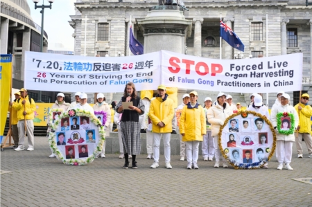 2025年7月22日,紐西蘭法輪功學員齊聚首都威靈頓,舉行遊行和集會,呼籲立即停止對法輪功長達26年的迫害、解體中共。圖為主持人在講述法輪功學員程靜(中間站立者右一)和李紅洲(中間站立者右二)在大陸被迫害的遭遇。(許英/大紀元)
