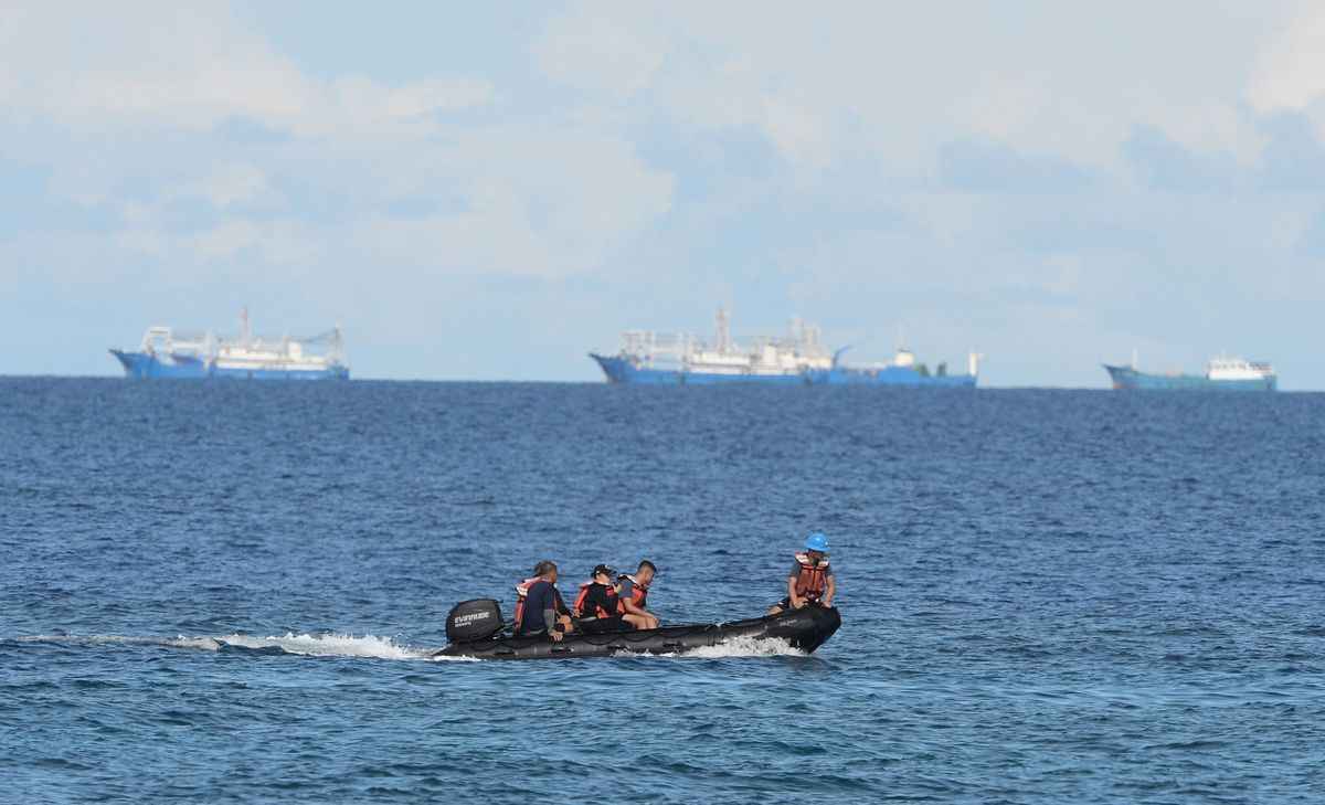 資料圖：2017年4月21日，菲律賓海警人員在南沙群島的中業島（Thitu）附近海域勘測中共宣稱擁有主權的渚碧礁（Subi reef，背景）。菲律賓當局當天表示，一群菲律賓漁民指責中共海警在有爭議的南海向他們的船隻開槍。示意圖。（TED ALJIBE/AFP via Getty Images）
