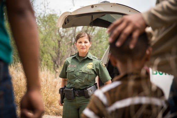 邊界巡邏隊一名員工Marlene Castro（中）與一群非法移民談話，這些非法移民在2017年5月26日從墨西哥越境到德州。（Benjamin Chasteen／大紀元）
