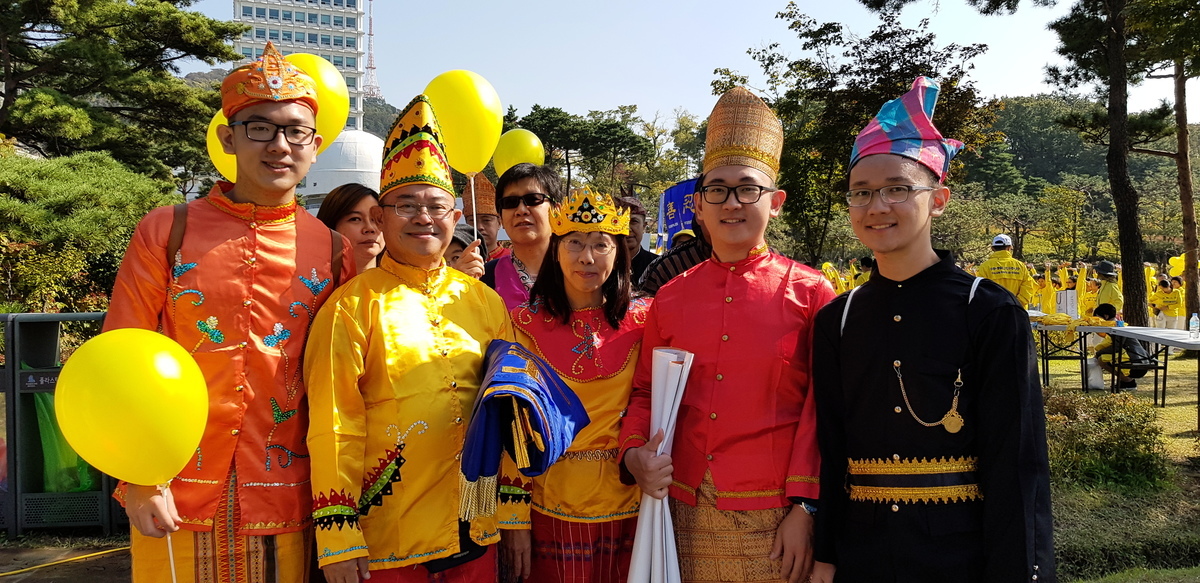 印尼的法輪功學員黃義任先生攜全家來到南韓，展示大法的美好。（駱亞／大紀元）