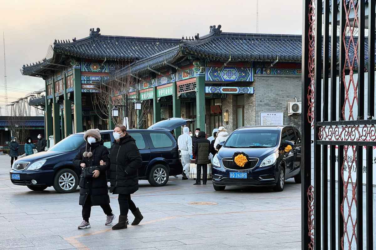 2022年12月17日，北京爆發COVID-19期間，一家殯儀館的身著防護服的工人在轉運屍體。（Alessandro Diviggiano/REUTERS）