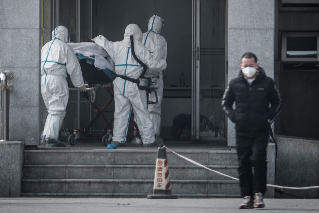  圖為2020年1月18日，一名病人被送入收治類似薩斯病毒感染者的武漢金銀潭醫院。（STR/AFP via Getty Images）