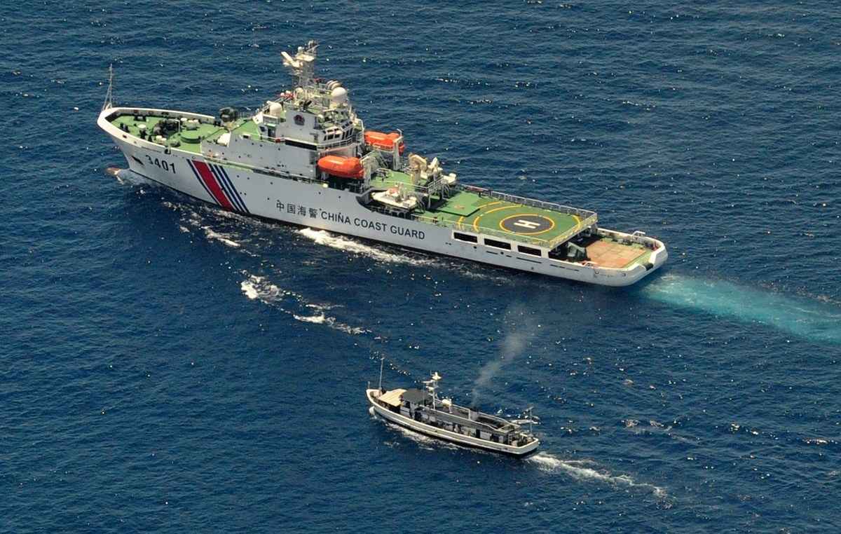 資料圖：2014年3月29日，一艘中共海警船（上）和一艘菲律賓補給船發生對峙，因為菲律賓船試圖到達第二湯馬士淺灘（Second Thomas Shoal，仁愛礁），這是一個偏遠的南海島礁，兩國都聲稱對其擁有主權。（Jay Directo/AFP via Getty Images）