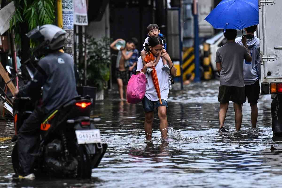 2026年8月17日，在菲律賓首都馬尼拉，多條街道因短時強降雨而嚴重積水，民眾被迫涉水而行。（Jam Sta Rosa/AFP via Getty Images）