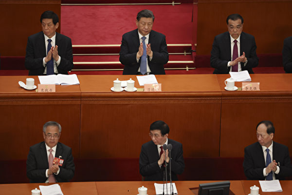 2023年3月4日,中共政協開幕會上,王滬寧坐在主席台第一排中間,胡春華(左)、石泰峰(右)在兩邊。習近平坐在第二排中間,栗戰書(左)、李克強(右)在兩邊。(Lintao Zhang/Getty Images)