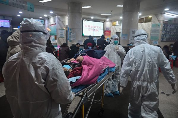 2020年1月25日，武漢紅十字醫院內醫護人員穿著防護服照顧染疫者。（Hector Retamal/AFP via Getty Images）