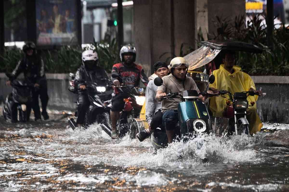 2026年8月10日，菲律賓首都馬尼拉遭暴雨襲擊後，民眾被迫涉水而行。（Ted Aljibe/AFP via Getty Images）