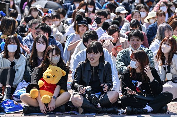 2023年4月10日，日本浦安市，東京迪士尼樂園舉行成立40周年的慶祝活動，遊客正在等待遊行開始。（Richard A. Brooks/AFP）