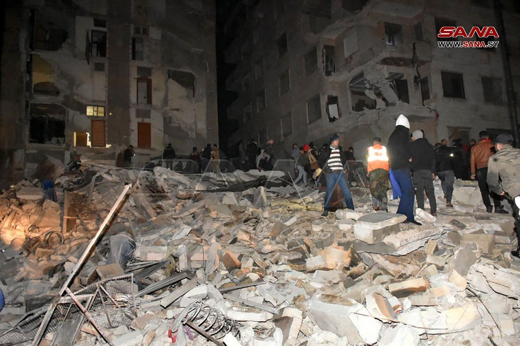 2023年2月6日，土耳其南部發生7.8級地震，以色列等多國有震感，其中敘利亞北部受到的波及強烈，多人死亡。圖為敘利亞哈馬的救援人員在廢墟中尋找倖存者。 （Photo by Handout / SANA / AFP）
