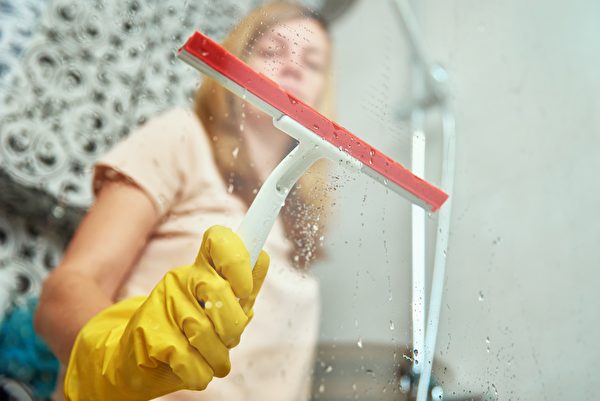  清潔玻璃門窗時，可用刮刀刮除水痕。（Shutterstock）