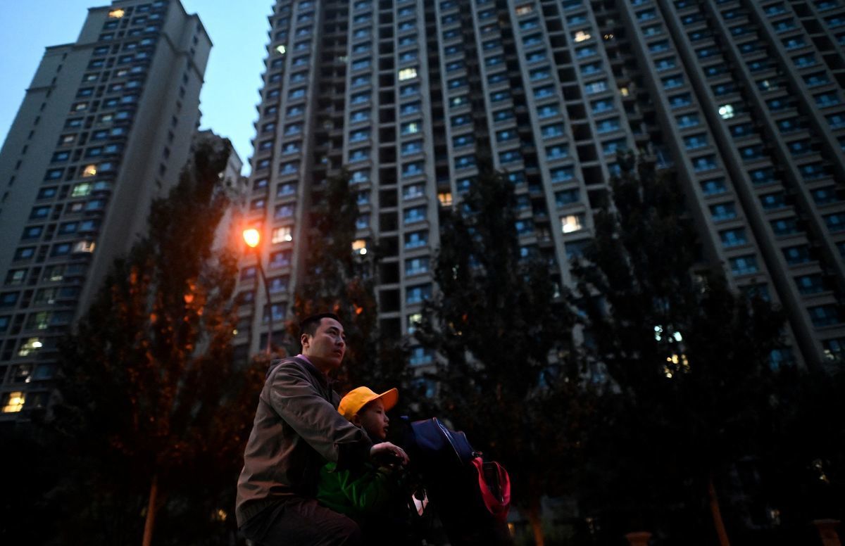 2021年10月25日，一名男子在中國房地產開發商恒大的北京住宅區前騎單車。（NOEL CELIS/AFP via Getty Images）