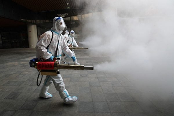 2022年1月11日，西安市衛生員穿著防護服在一個商場外面噴灑消毒劑。（STR/AFP via Getty Images）