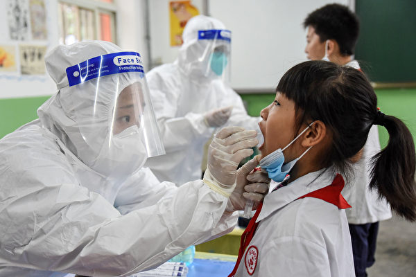 圖為2020年8月17日河北省邯鄲市的醫務人員正在採集小學生的口咽拭子樣本。（STR/AFP via Getty Images）