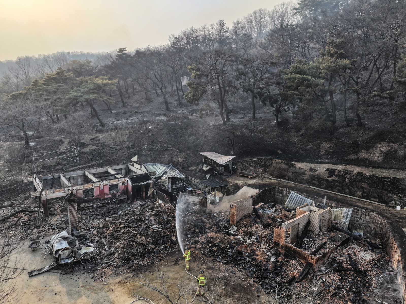 2025年3月23日,消防員撲滅了慶尚北道義城郡雲羅寺的大火,但這座古老的寺廟幾近焚燬。(YONHAP/AFP)