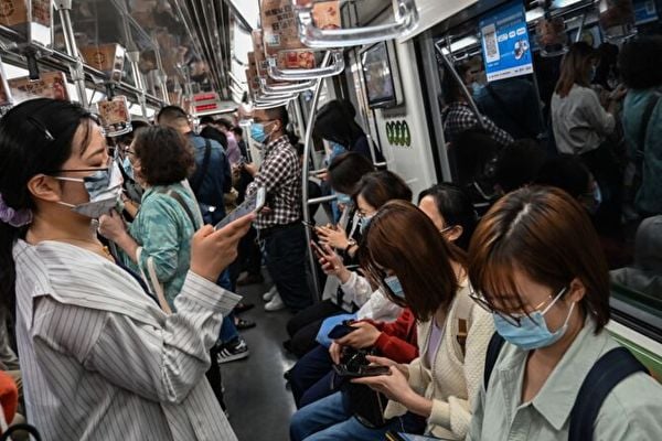 圖為2021年10月21日，上海地鐵車廂裏的民眾。（HECTOR RETAMAL/AFP via Getty Images）