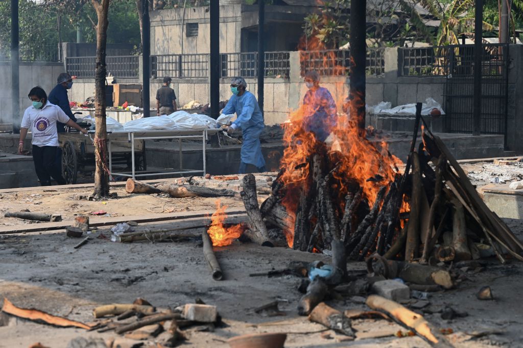 2021年5月5日，在新德里一家火葬場，中共病毒（武漢肺炎）死者親人在用擔架運送死者屍體。（SAJJAD HUSSAIN/AFP via Getty Images）