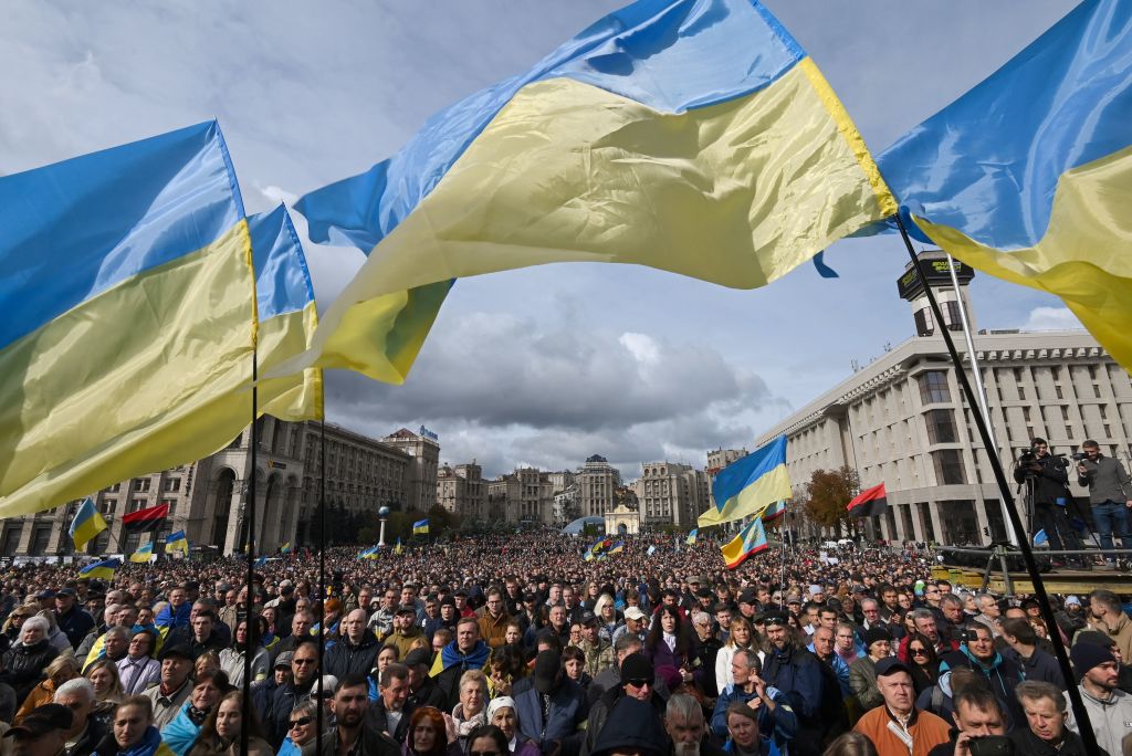 圖：2019 年 10 月 6 日，烏克蘭示威者在首都基輔市中心聚集時揮舞著國旗，以抗議給予分離主義者更廣泛的領土自治權，這是結束與俄羅斯支持的派別戰事的一個部份。抗議者高呼口號「絕不投降！」，還有一些人舉著批評烏克蘭總統弗拉基米爾·澤連斯基（Volodymyr Zelenskyy）的標語牌，警方稱示威者已達上萬人。（Genya Savilov/AFP via Getty Images）