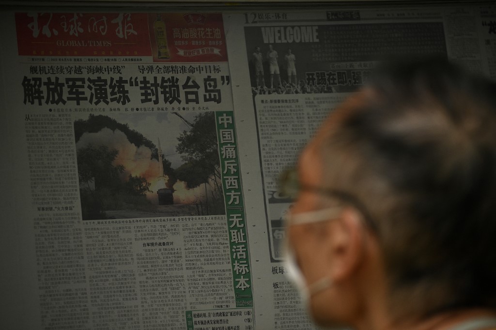 2022年8月8日，一名男子在北京的一條街道上閱讀有關中共軍演的文章。（Noel Celis / AFP）