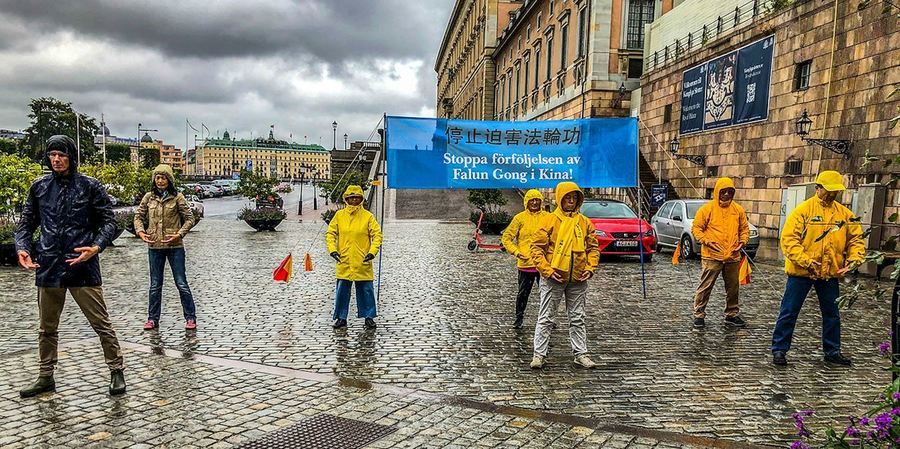 國會前 瑞典人冒雨圍著法輪功學員聽真相