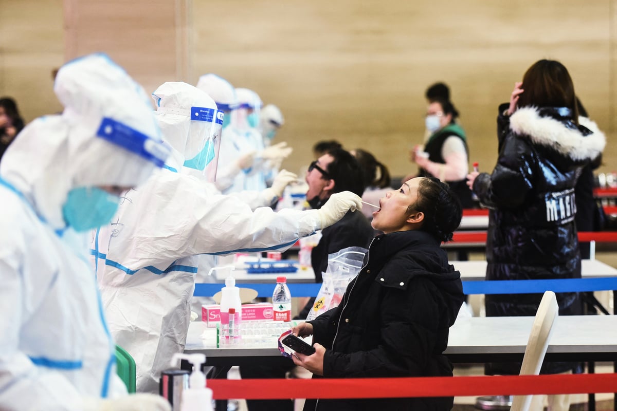 2021年12月15日，浙江醫務人員正在對杭州市民採集咽拭子樣本。（STR/AFP via Getty Images）