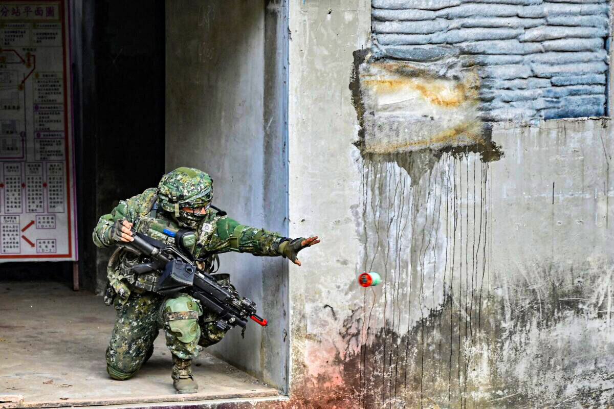2022年1月6日，一名台灣士兵在高雄一個陸軍基地的演習活動中投擲了一枚煙霧彈。（Sam Yeh/AFP via Getty Images）