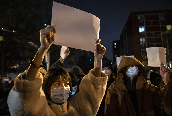 2022年11月27日，北京居民在街頭舉著白紙抗議，隨後外界稱之為「白紙革命」。（Kevin Frayer/Getty Images）