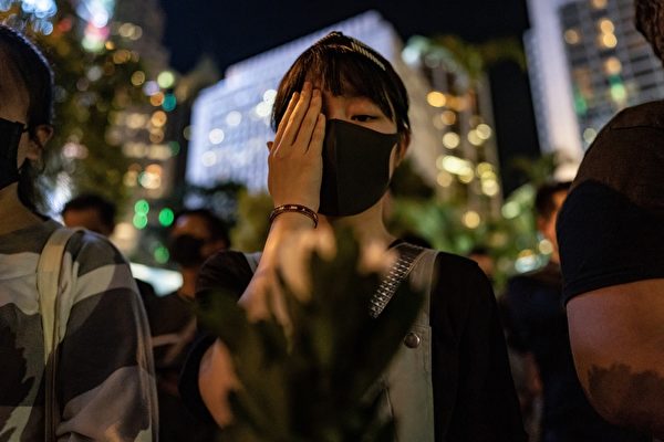 2019年8月30日晚上8點，香港民眾在中環和平紀念碑舉辦重光紀念日默站活動，參與民眾做出掩右眼手勢。（Anthony Kwan/Getty Images）