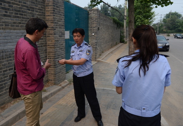 圖為中國警方檢查來訪記者的證件。（Mark Rolston/AFP/GettyImages）