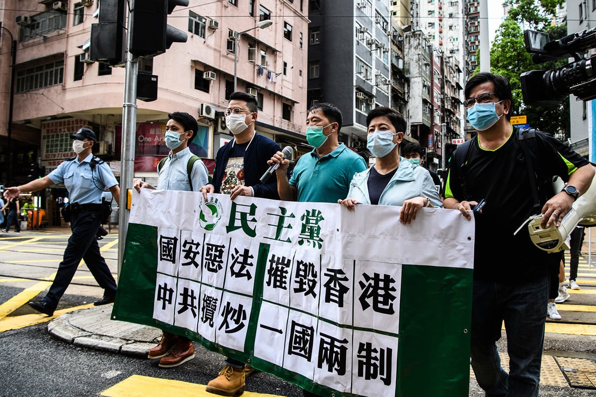 圖為香港民主抗議人士5月22日拿著標語牌，抗議中共對香港強加國安法。（Anthony WALLACE / AFP）