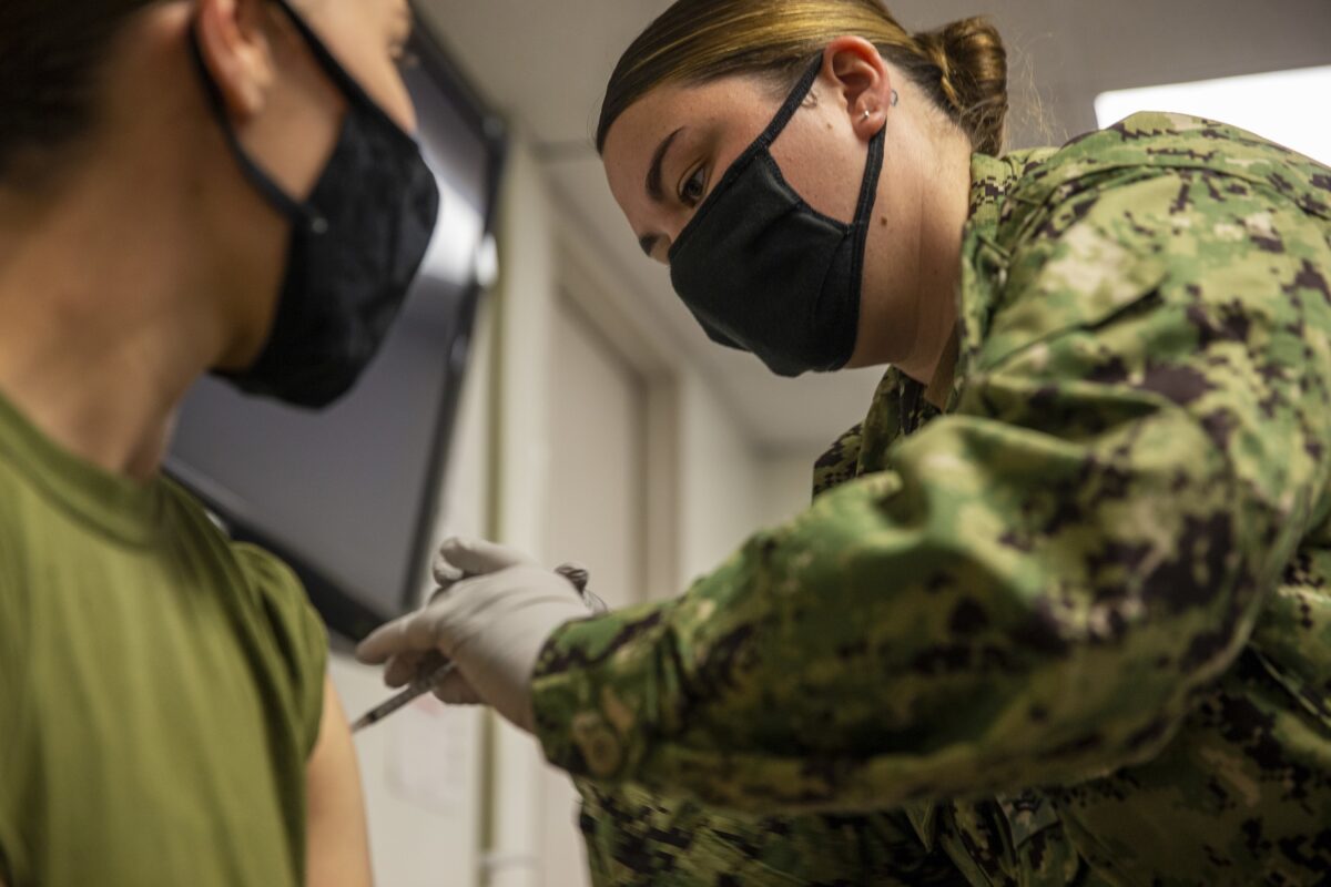   2021年9月22日，一名海軍士官在加利福尼亞州彭德爾頓營地（Camp Pendleton）為一名海軍陸戰隊隊員接種COVID-19疫苗。（U.S. Marine Corps photo by Cpl. Andrew Cortez via The Epoch Times）