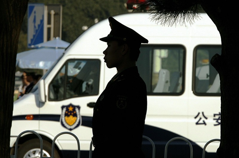一名中國警察站在警車前。資料照。（PETER PARKS/AFP/Getty Images）
