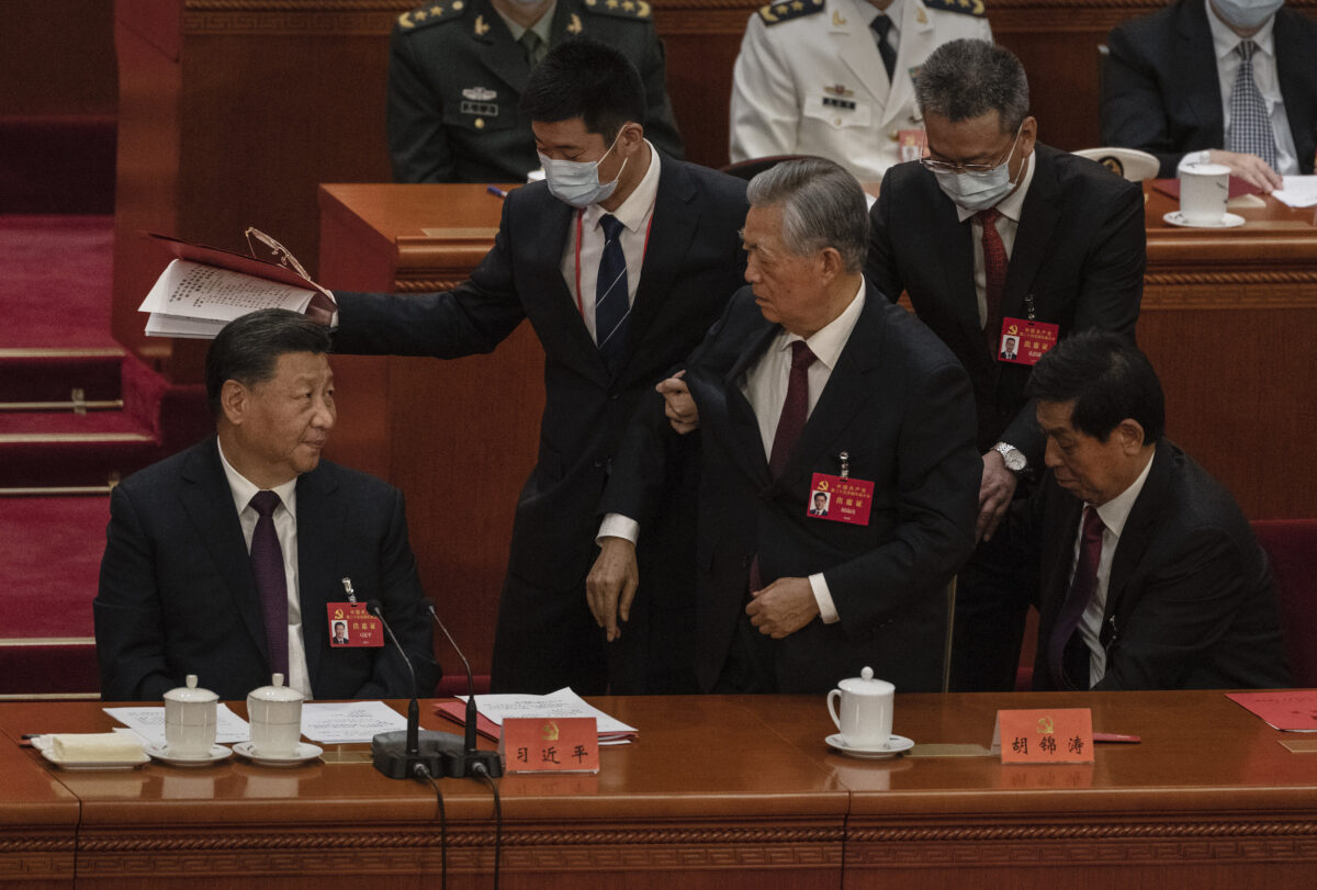 2022年10月22日，在北京人民大會堂，中共總書記習近平（左）看著前總書記胡錦濤在中國共產黨第二十次全國代表大會閉幕式上「被離開」。（Kevin Frayer/Getty Images）