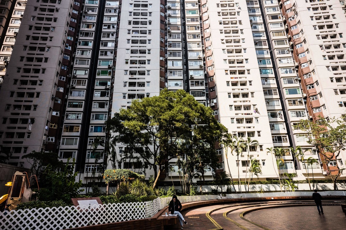 日本金融專家警告說，中國房地產已經出現類似於日本上世紀80年代泡沫經濟的跡象。圖為2019年1月22日，一名女子坐在香港一棟公寓大樓前。（ANTHONY WALLACE/AFP/Getty Images）