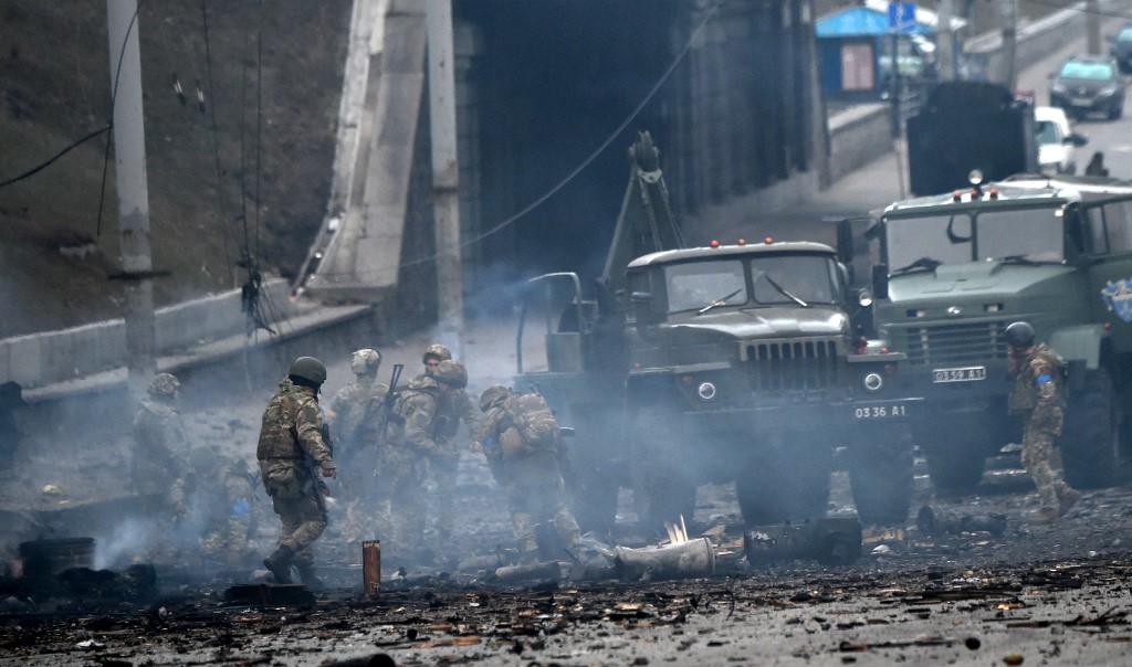 2022年2月26日，烏克蘭軍事人員在基輔與俄羅斯襲擊小組戰鬥後收集未爆炸的砲彈。（Sergei SUPINSKY / AFP）